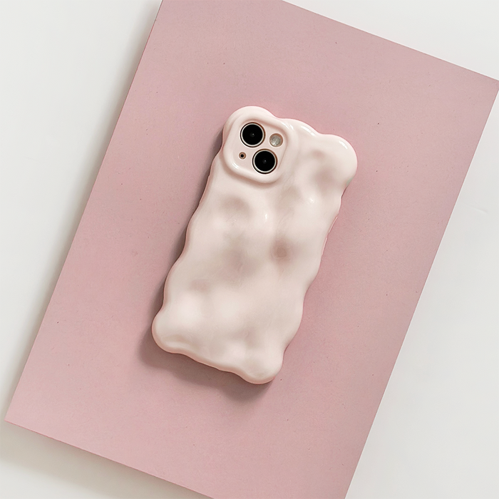 White phone with a pink 3D bubble case on a pink sheet, set against a white background.