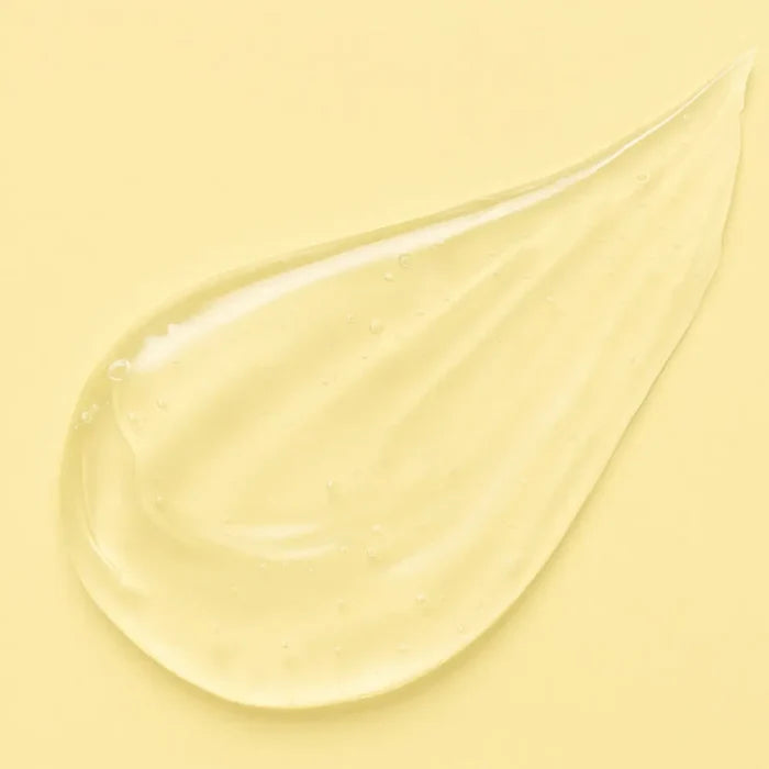 Clear curl-defining gel with bubbles on a soft yellow background for curly hair care