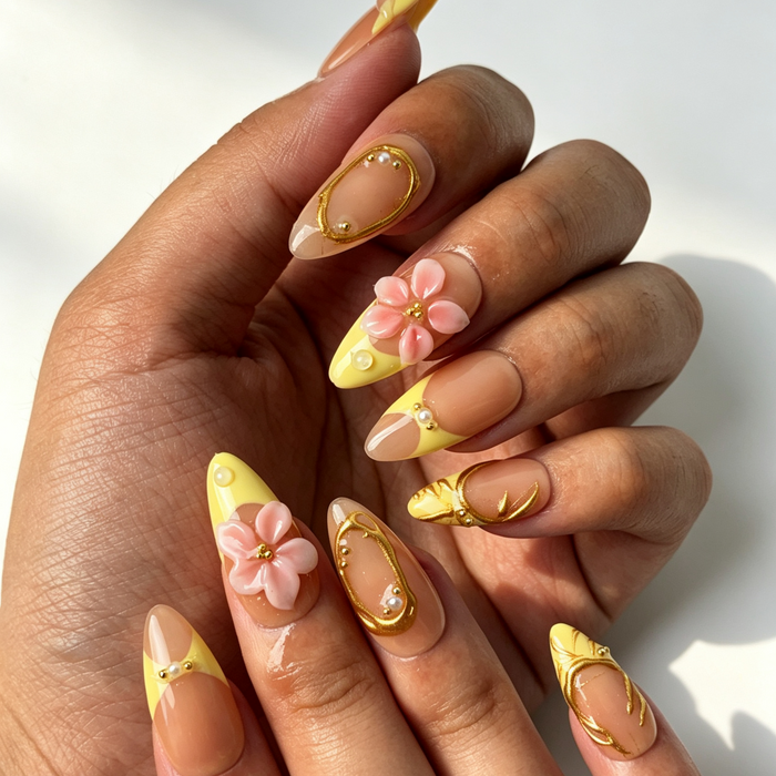 Romantic gold foil pearl floral fake nails close‑up hand shot