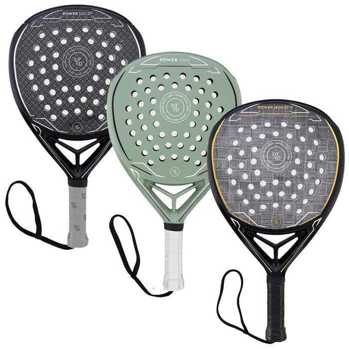 Three padel rackets are displayed, each with a distinct design and color. They are positioned with handles facing downward, showcasing their perforated faces and string patterns against a neutral background.