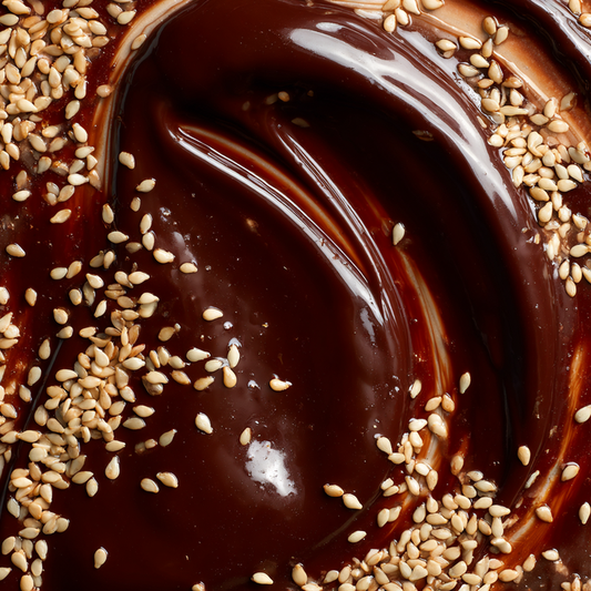 Close-up of a dessert with chocolate sauce and sesame seeds