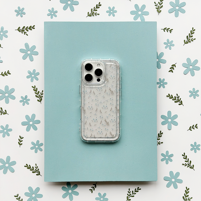 Clear phone case with blue floral pattern, shown against a blue surface with matching flower design in the background.
