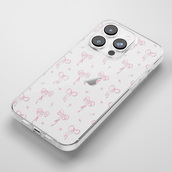 Clear iPhone 15 case with pink bows and dot pattern on a white background.