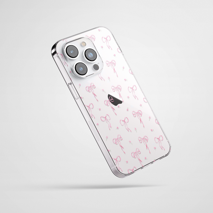 Clear iPhone 15 case with a pink bows pattern by Coconut Lane, displayed on a white background.