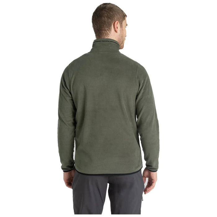 A person is wearing a green fleece jacket with a high collar and facing away from the viewer in a neutral background. The attire appears casual and suitable for outdoor activities.