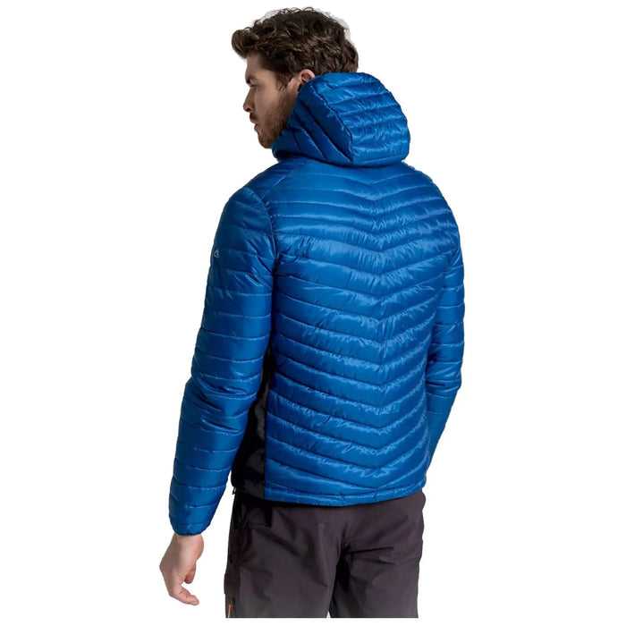 A person is standing with their back facing the viewer wearing a bright blue puffy jacket with a hood the setting appears to be neutral and indoor with no distinct environment details visible