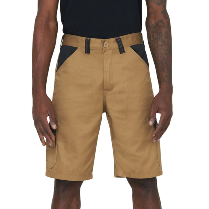 Tan shorts are worn by a person standing upright with hands at their sides The shorts feature black accents near the pockets and are part of a casual outfit in a neutral setting