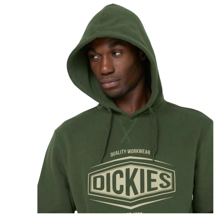 A young man with a serious expression wears a green hoodie featuring the brand name in large letters. He is facing slightly to the side against a plain background.
