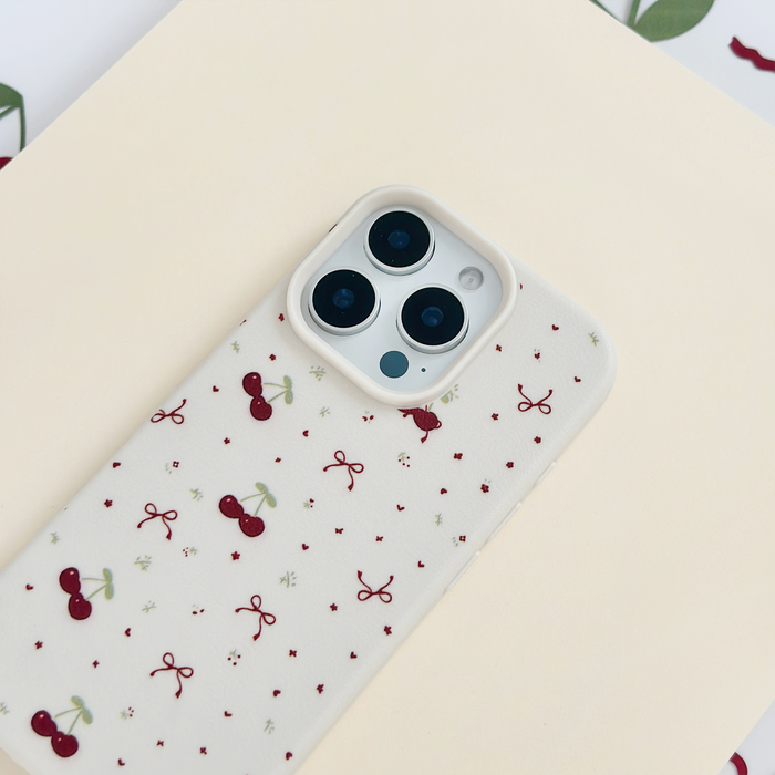 Coconut Lane Ditsy Bows & Cherries soft white phone case with small bow and cherry pattern on a smartphone.