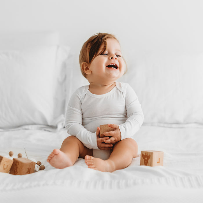 Baby wearing a Dreamskin long-sleeve eczema bodysuit