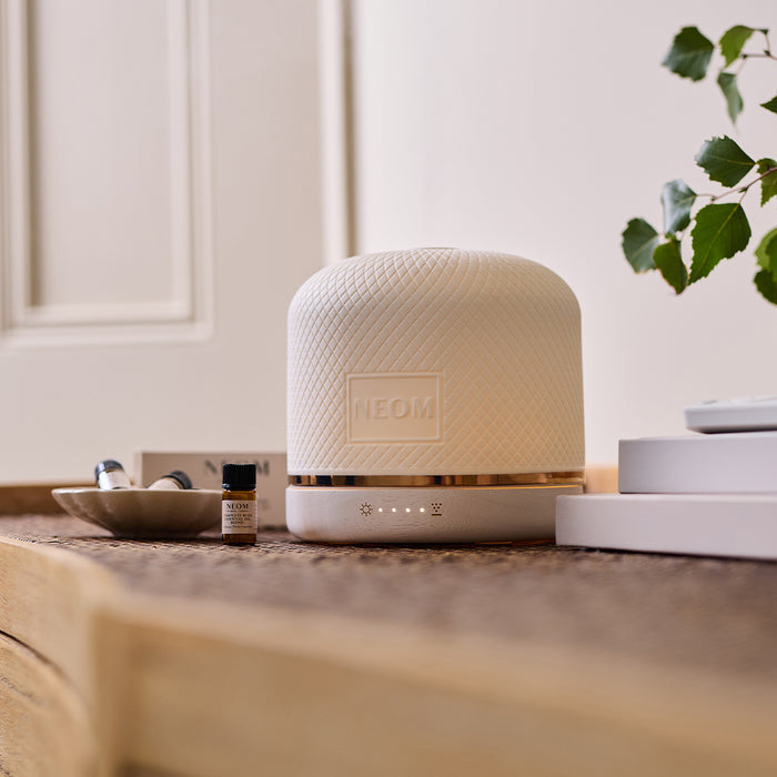 NEOM pod luxe with essential oil blends on a table