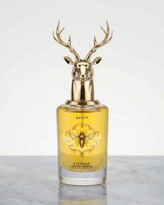 Eternia Guilty eau de parfum bottle with gold deer antler cap, amber glass
