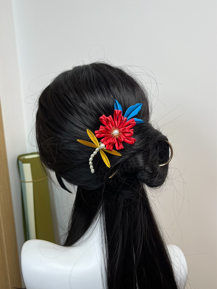 A handmade Chanhua chrysanthemum hair comb adorned in a dark - haired updo