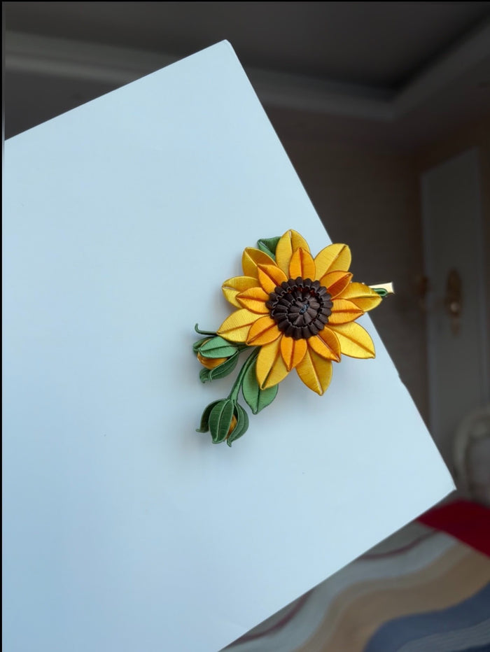 Handmade Chanhua sunflower hair clip on a white surface