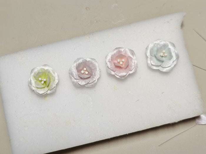 Four handmade Ronghua jasmine earrings in different colors on a white surface