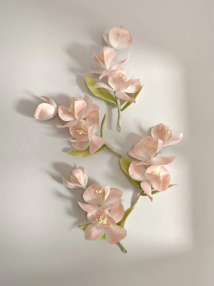 Handmade Ronghua pink iris hair accessory with multiple flowers and green leaves