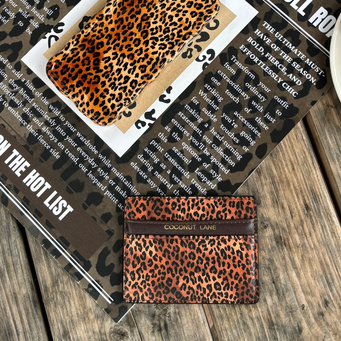 Leopard print card holder on a matching leopard print magazine page, placed on a wooden surface.
