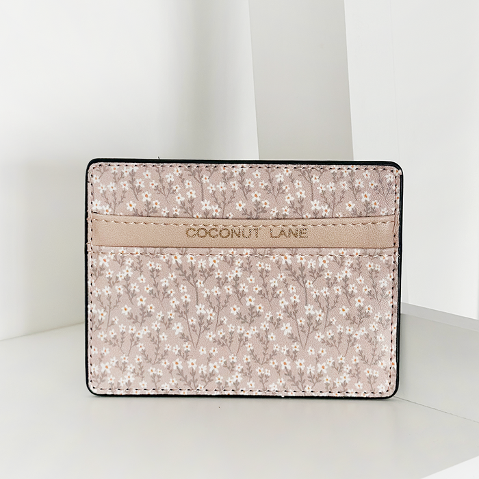 Nude floral vegan leather card holder with COCONUT LANE embossed, displayed on a white surface.