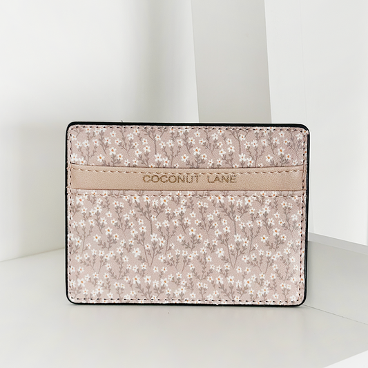 Nude floral vegan leather card holder with COCONUT LANE embossed, displayed on a white surface.