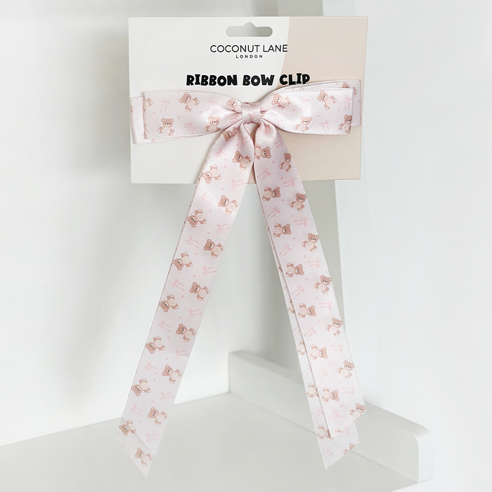 Pink satin bow hair clip with a subtle teddy bear pattern from Coconut Lane.