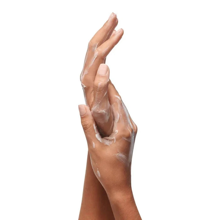 Close-up of hands with a white cream on a white background