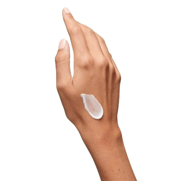 Hand with a small amount of cream on the palm against a white background