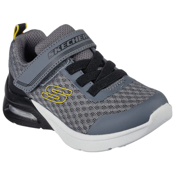 A gray sneaker with black laces and a Velcro strap is positioned prominently displaying a textured mesh design and a yellow logo on the side, intended for athletic use.