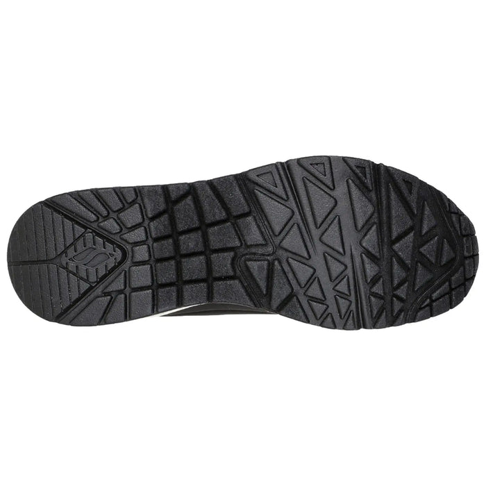 A black athletic shoe sole is viewed from below showcasing its textured surface and tread pattern designed for grip and stability on various terrains.