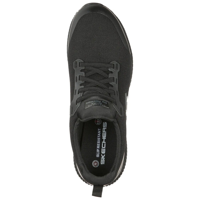 A black sneaker with a textured upper laces through eyelets rests flat. The insole features "SKECHERS" and "SLIP RESISTANT" indicating functionality. Designed for comfort and safety in various environments.