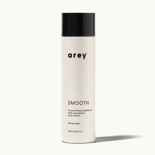 Arey Smooth Conditioner bottle on a cream background. Label reads: arey. SMOOTH. A nourishing conditioner that strengthens and softens. All hair types. 250ml / 8.45 fl oz.