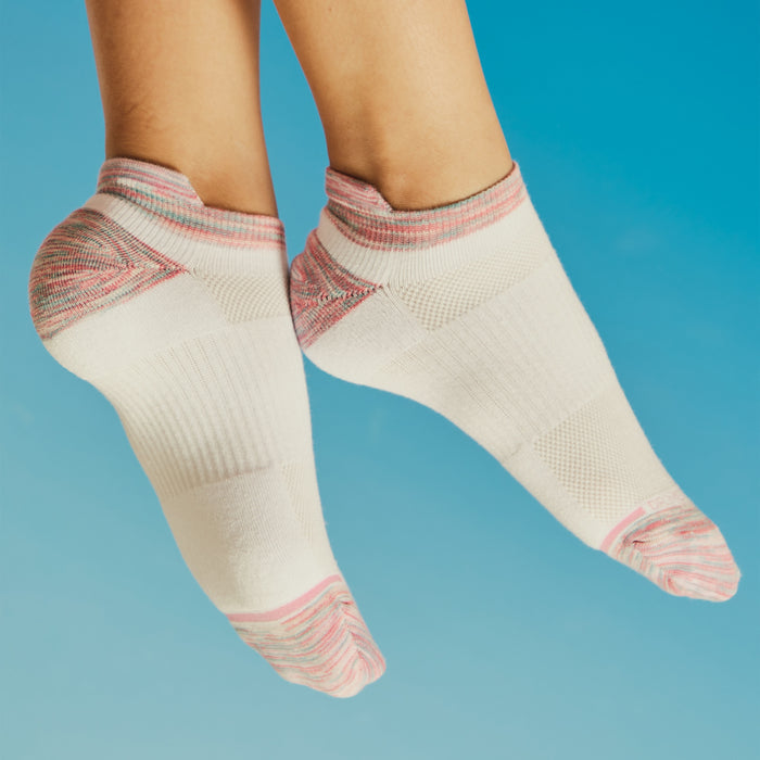 Ankle compression socks in white with pink and gray accents, displayed against a blue background.