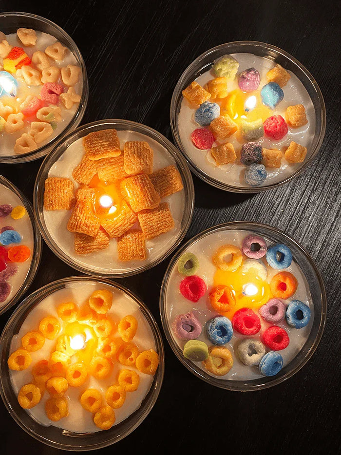 Scented candles shaped like colorful cereal bowls on a dark surface