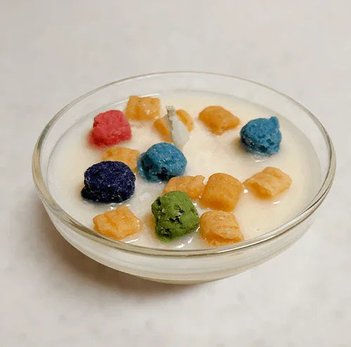 Colorful cereal-inspired dessert candle in a glass bowl with milk-like wax and wick