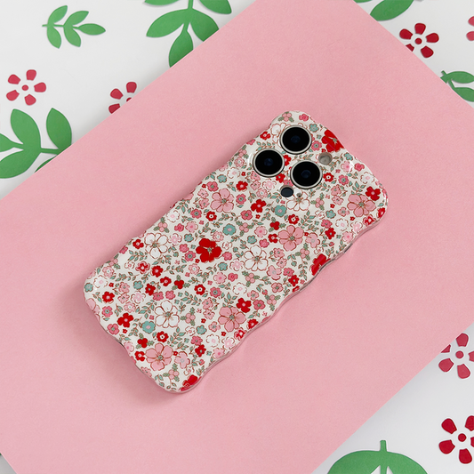 Coconut Lane wavy phone case with cute floral pattern, shown on a pink surface and colorful floral background.